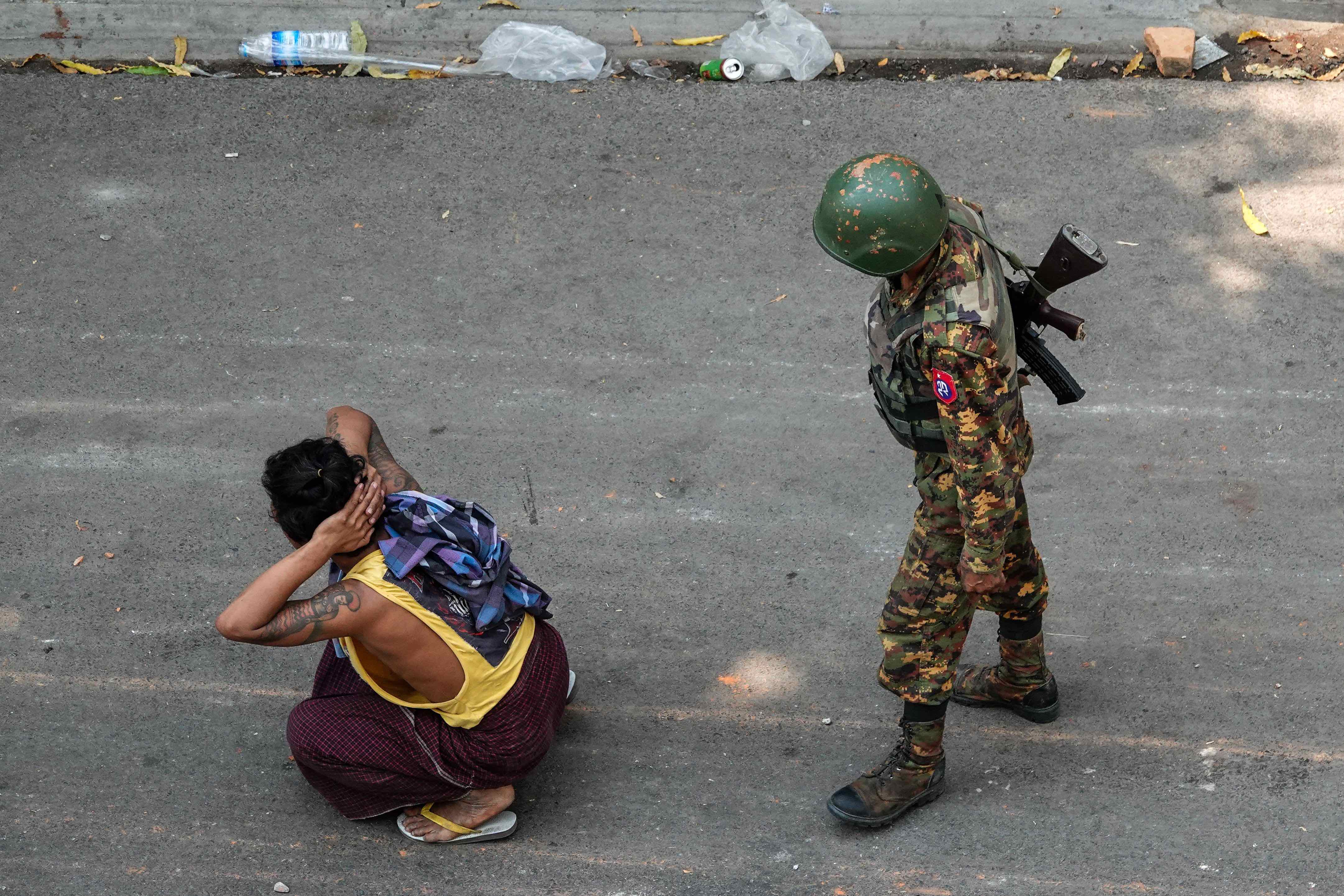 A soldier stands next to a detained man during a demonstration against the military coup in Mandalay in March 2021 (Photo: STR / AFP)